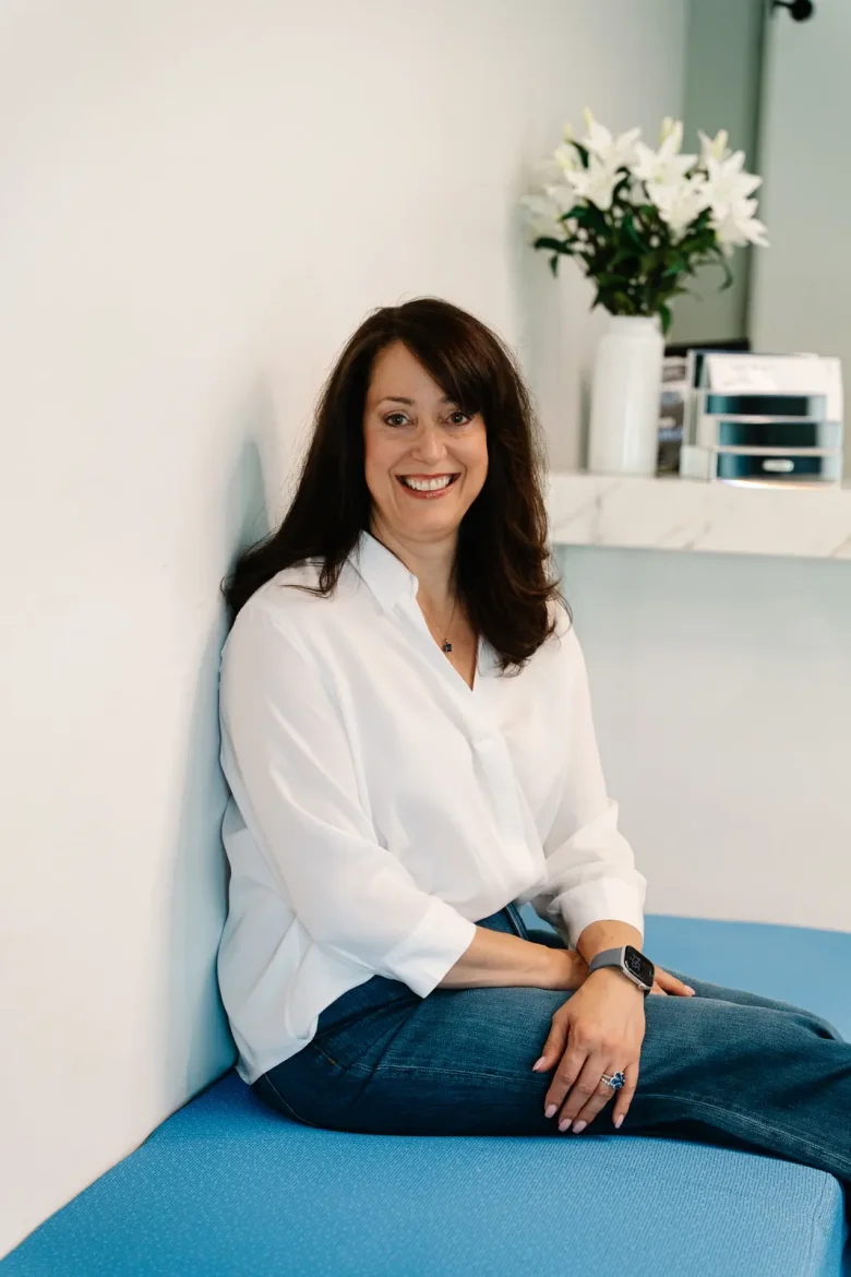 Christine DiNoia, BSN, RN, seated on a bench in her office