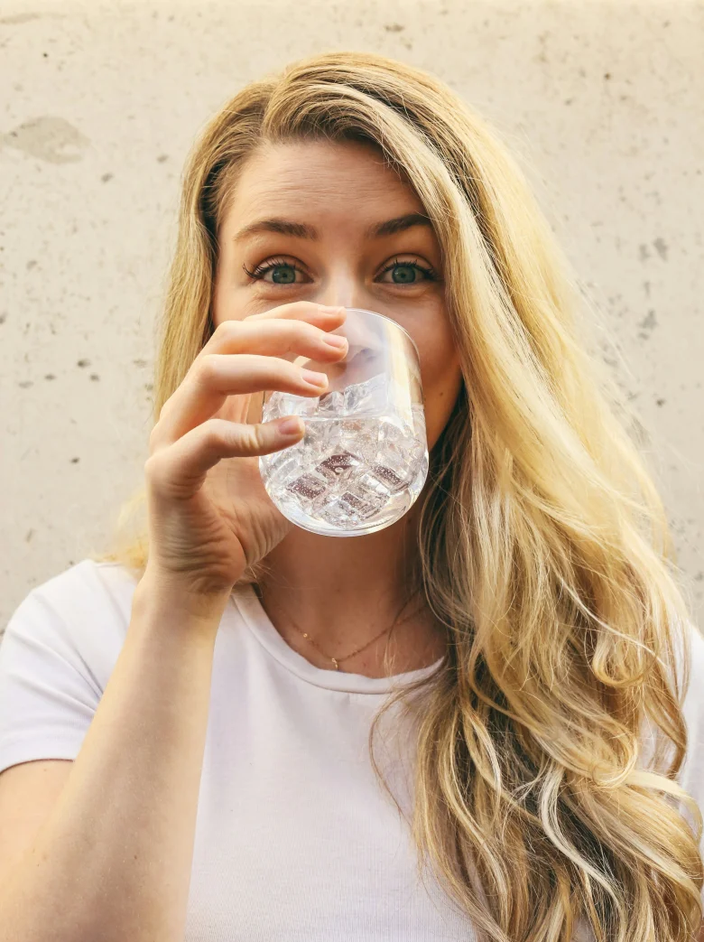 Woman in a white shirt drinking water